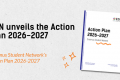 On a light grey textured background, large black text on the left reads “ESN unveils the Action Plan 2026–2027,” with orange italic text below stating “Erasmus Student Network’s Action Plan 2026–2027.” On the right, a tilted image of the Action Plan 2026–2027 booklet cover is displayed, featuring the ESN logo and title. Decorative orange doodles and accents surround the booklet, with a vertical blue bar along the left edge of the graphic.
